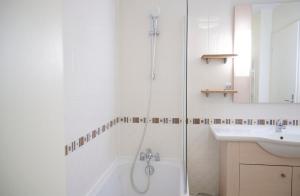 a white bathroom with a shower and a sink at Studio climatisé à Divonne-les-Bains in Divonne-les-Bains +10 photos