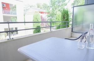 a white table on a balcony with a large window at Studio climatisé à Divonne-les-Bains in Divonne-les-Bains