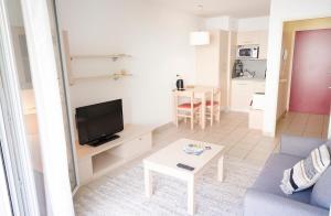 a living room with a blue couch and a table at Studio climatisé à Divonne-les-Bains in Divonne-les-Bains