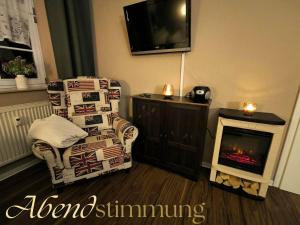 a living room with a chair and a fireplace at Apartment London Garten & Pool als Extra möglich barrierefrei in Mühlhausen