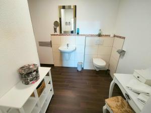 a small bathroom with a toilet and a sink at Apartment London Garten & Pool als Extra möglich barrierefrei in Mühlhausen