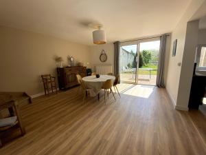a living room with a table and chairs and a large window at Le Neuvillois, Charming house 6p in Neuville-sous-Montreuil +21 photos