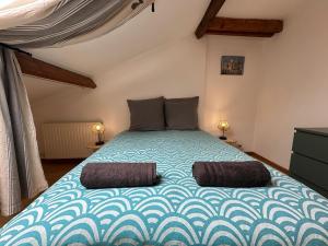 a bedroom with a large bed with two pillows at Le Neuvillois, Charming house 6p in Neuville-sous-Montreuil