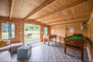 a room with a pool table in a wooden room at The Farmhouse Boundary Farm Framlingham in Woodbridge