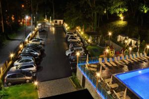 um parque de estacionamento com carros estacionados ao lado de uma piscina à noite em Park Hotel Asenevtsi em Veliko Tŭrnovo