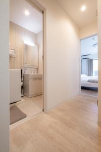 a room with a door leading to a kitchen at GuesthouseA in Osaka