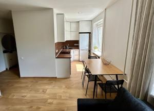 a kitchen and dining room with a table and chairs at Baika's SELF check-in apart in Klaipėda