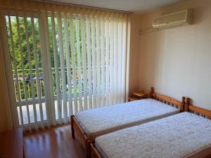 a bedroom with a bed and a large window at 2-комнатные апартаменты у моря 10 бассейнов Crown Fort Noks in Sveti Vlas +64 photos