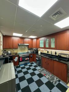 a large kitchen with a black and white checkered floor at Happy Dom Vibes JBR in Dubai