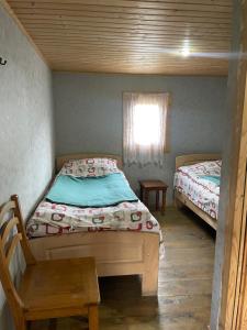 a small bedroom with two beds and a window at Guesthouse Tushetian Tower in Omalo +14 photos