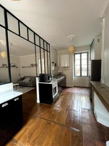 a large kitchen with wooden floors and a large window at Beautiful accommodation - Hypercentre Marketplace in Cahors