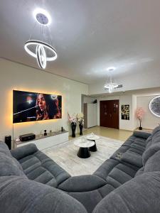 a living room with a couch and a flat screen tv at Happy Dom Vibes JBR in Dubai