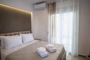 - une chambre avec 2 serviettes sur un lit et une fenêtre dans l'établissement The Cozy Twins, à La Canée