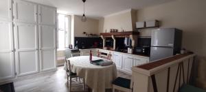 a kitchen with a table and a refrigerator at Villa Margo in Cognac