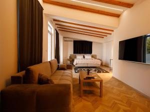 a living room with a couch and a tv at Velvet Apartments in Strumica +19 photos