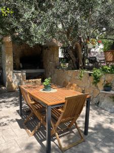 a wooden table and chairs in front of a stone oven at Superior Apartman Vujević, Duće in Duće