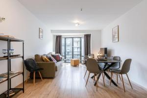 a living room with a table and a couch at Huswell - Bright & Stylish Apartment with Balcony in Knokke-Heist