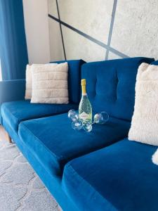 a blue couch with a bottle and glasses on it at Apartament Poznańska 1 in Suwałki +29 photos