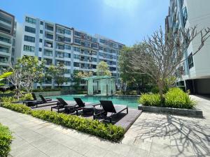 a group of chairs sitting next to a swimming pool at 1 Bedroom Condos Close to Shopping Malls in Ban Rangeng