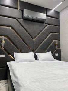 a bedroom with a white bed with a black wall at TuranWay Apart 1 NRG U Tower in Tashkent