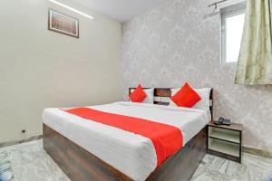 a bedroom with a large bed with red pillows at HOTEL O THE ROYAL INN in Jaipur