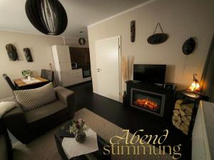 a living room with a fireplace in a living room at Apartment Kapstadt Garten & Poolnutzung als Extra möglich in Mühlhausen +15 photos