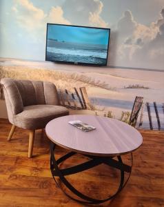 Una sala de estar con una silla y una mesa. en Ferienwohnung Seemöwe Usedom, en Heringsdorf