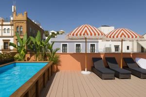 a balcony with two umbrellas and a swimming pool at The Loft House Sevilla in Seville
