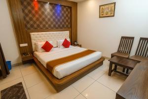 a bedroom with a bed with red pillows and a desk at Hotel JP International in Katra