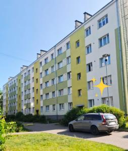a building with a car parked in front of it at Magnolija in Liepāja