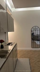 a kitchen with a sink and a mirror on the wall at شقة بغرفة نوم وصالة in Buraydah