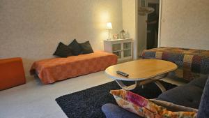 a living room with two beds and a coffee table at Vehkaojan Kotoisa in Jämsä