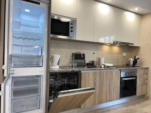 a kitchen with an open refrigerator and a sink at Ed Elite 3F Apartamento a 5 min a pé da Praia da Rocha com piscina e garagem in Portimão