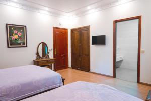 a bedroom with a bed and a mirror and a tv at Pearl Hotel Ha Long in Ha Long