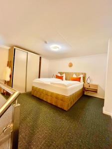 a hotel room with a large bed with orange pillows at Allgäuer Ferienwohnung mit Schwimmbad- und Sauna-Zugang in Wiggensbach +9 photos