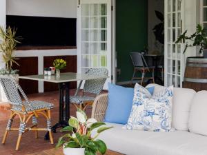 a living room with a white couch and a table at Whispering Oaks Guest House in George