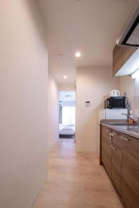 a kitchen with a counter and a microwave at GuesthouseA in Osaka +51 photos