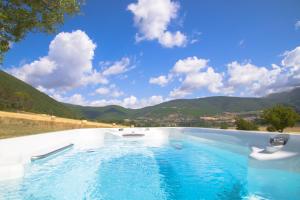 a swimming pool with mountains in the background at Agriturismo La Cascina di Opaco in Norcia