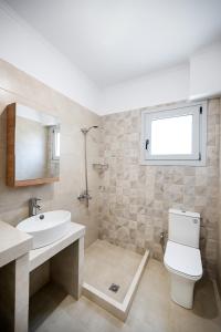 a bathroom with a sink and a toilet and a window at K city apartments in Lefkada Town +13 photos