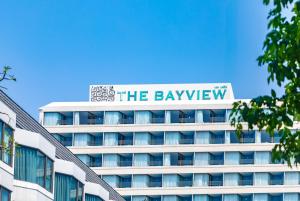 パタヤ・セントラルにあるThe Bayview Hotel Pattayaの上に看板がある建物