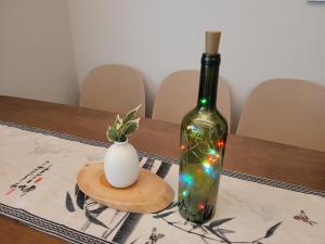 a bottle of wine and a vase on a table at Hello Stay & Hangang Park, 5 min walk from Konkuk University, Seongsu, Jayang Subway Stations & Licensed Accommodation in Seoul