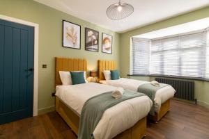 two beds in a room with green walls at LuNa Apartment-3bed Sleeps 6 - FamilyContractors in Elswick