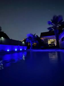une piscine la nuit avec des lumières bleues dans l'établissement Chambre chez l'habitant avec piscine 400m Circuit 24h Le Mans, au Mans