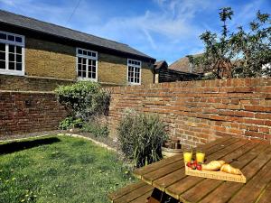 a wooden table with a tray of bread and drinks on it at Prospect Cottage in Hythe