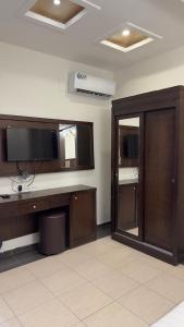 a room with a desk with a television and a mirror at شاليهات رميس للعائلات in Abha