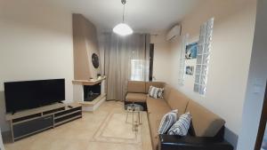 a living room with a couch and a television at Andreadis maissonette in Skala Potamias