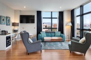 a living room with a blue couch and chairs at Catalonia Málaga in Málaga