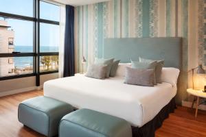 a bedroom with a large bed with a large window at Catalonia Málaga in Málaga