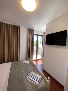 a bedroom with a bed and a flat screen tv at Vila Loris in Voskopojë