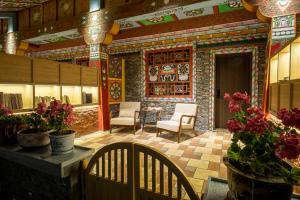 una stanza con due sedie e un tavolo con fiori di Jiuzhaigou Jijian Nanshan B&B a Valle del Jiuzhaigou